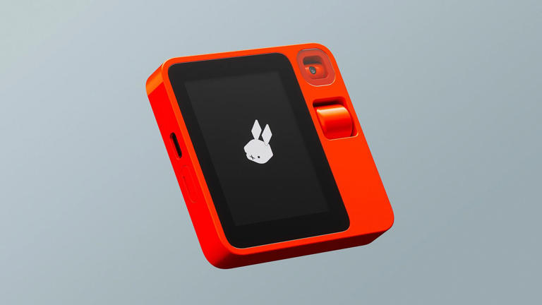 The Rabbit R1 - a small orange device with a black screen displaying a Rabbit head icon 