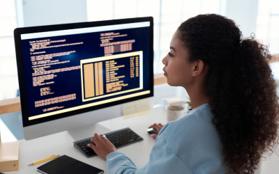 A woman looking at a computer screen displaying code