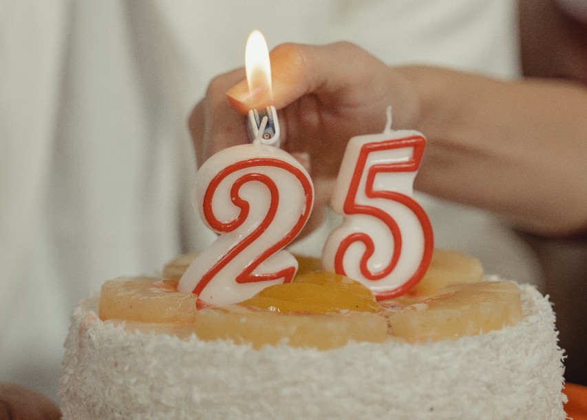 Person lights candles with 25 on them