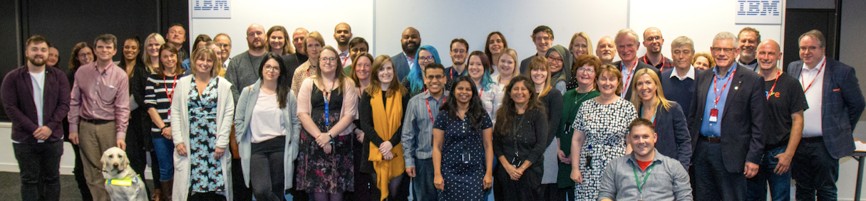 AbilityNet staff together at our 2019 Company Day, standing together as a group, everyone smiling at the camera