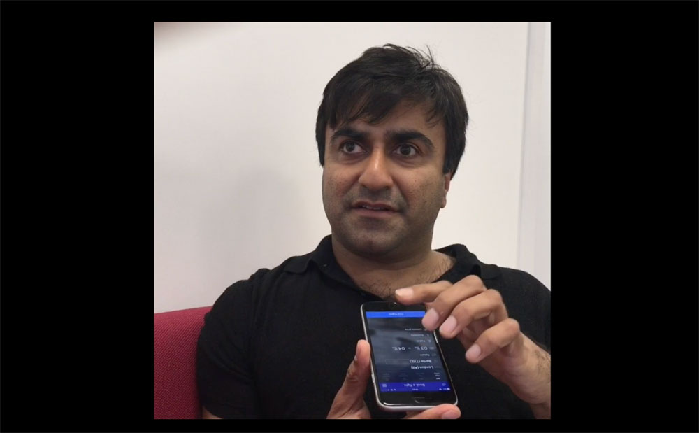 Image of Adi Latif using mobile technology as a blind user