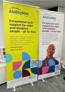 Two upright promotional banners for AbilityNet shown standing in a room next to each other