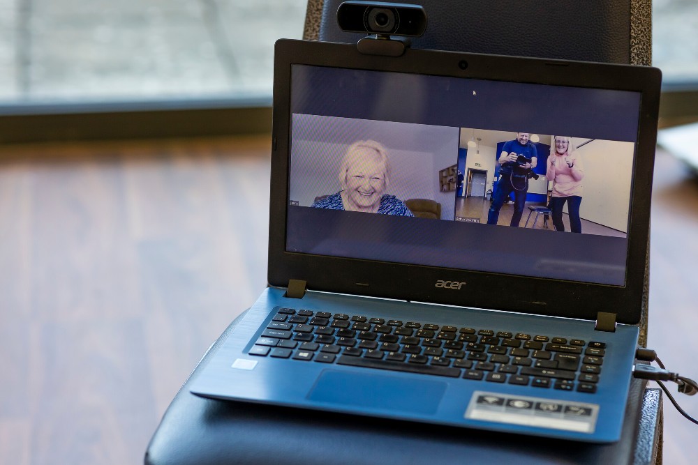 Computer with smiling older people on it in a group online call