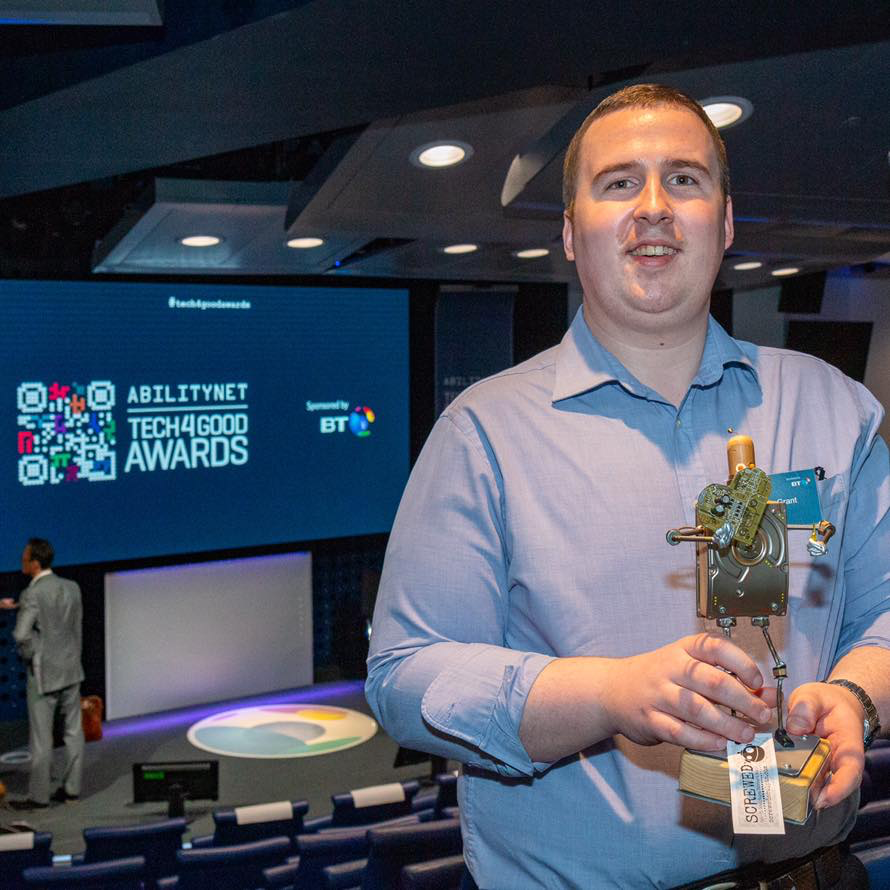 Image shows Chris holding his award at the 2019 Tech4Good Awards