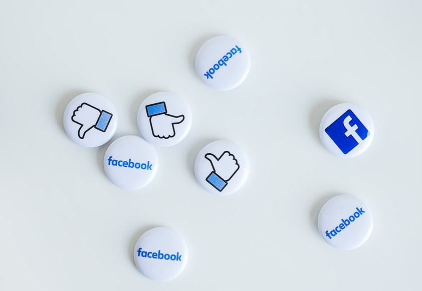 Facebook badges with the Facebook logo and thumb sign scattered