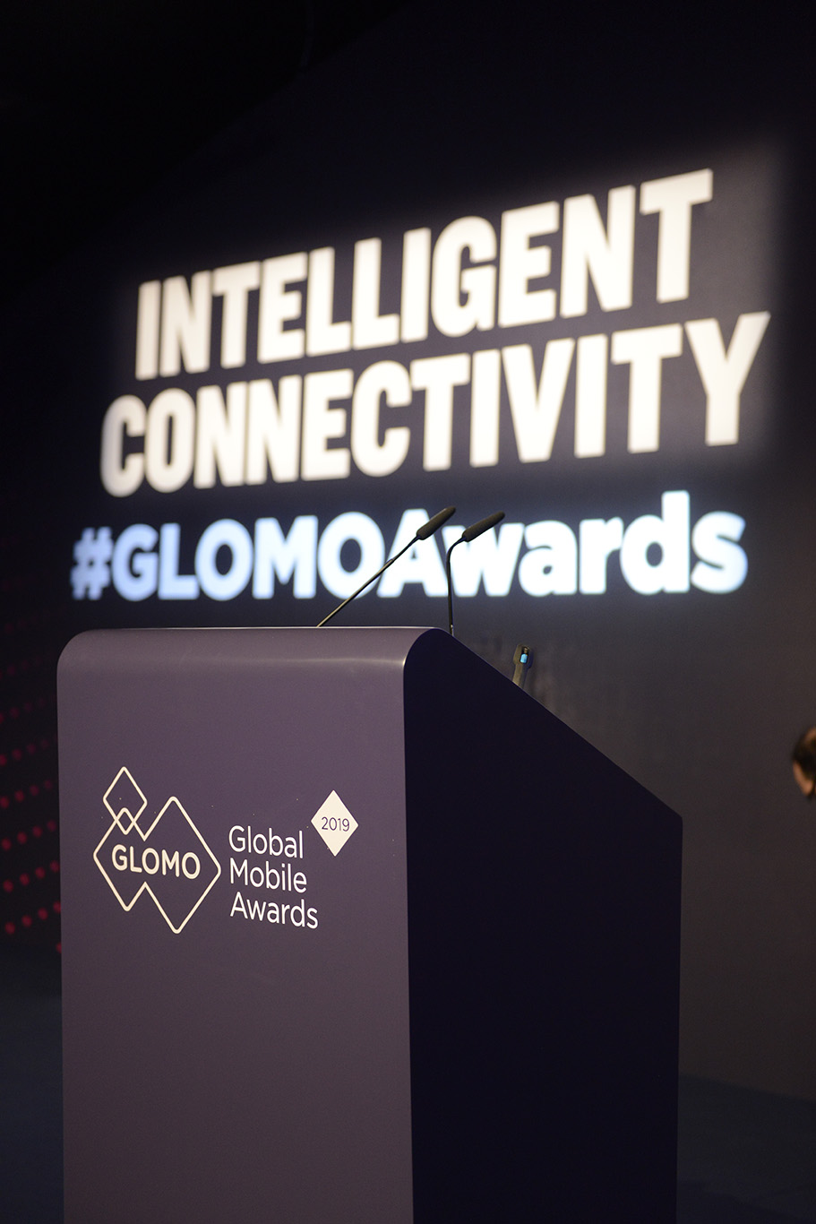 Podium set for announcing the winners at the GloMo Awards ceremony. "Intelligent connectivity #GLOMOAwards" on the backdrop