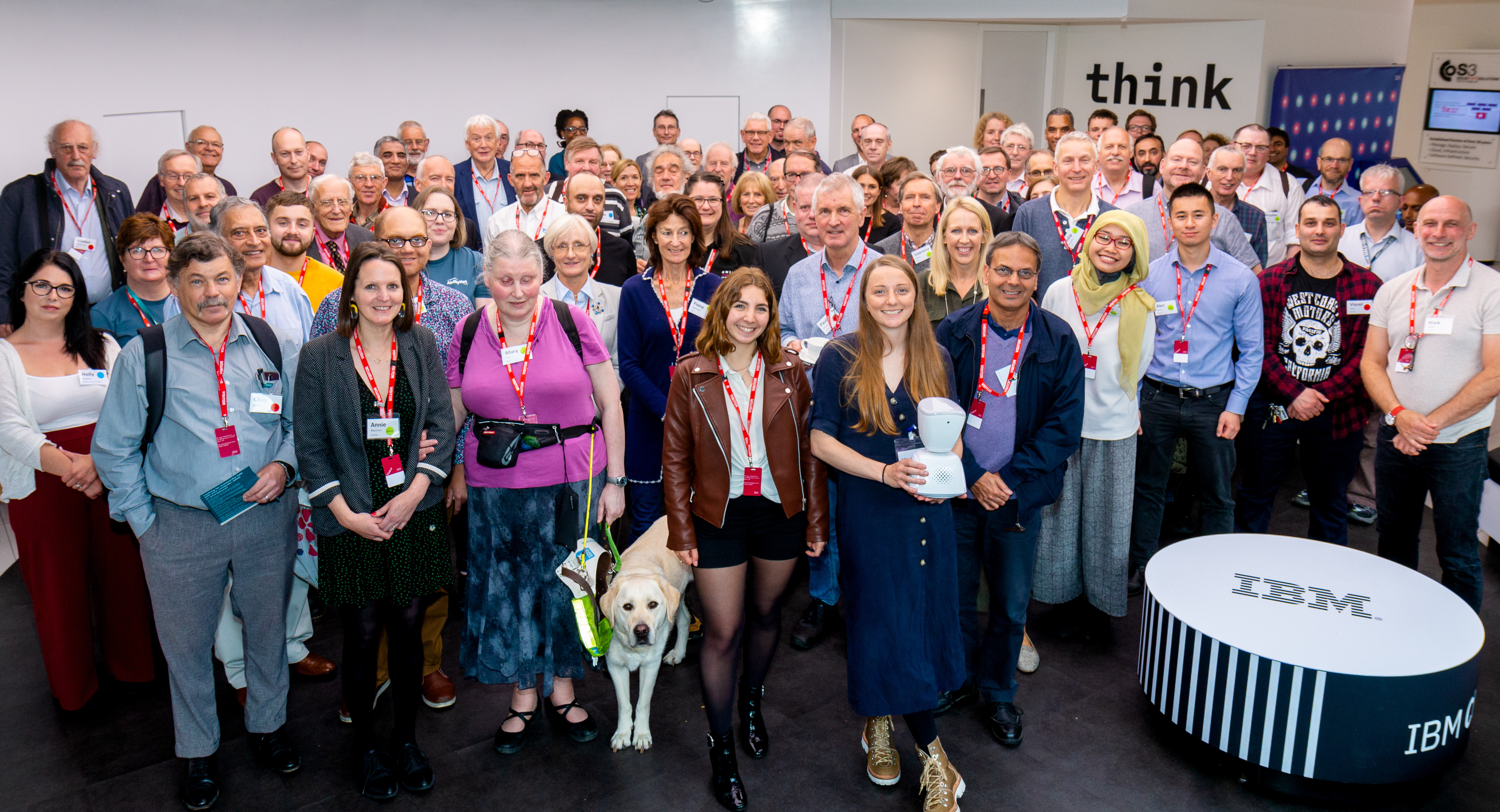 AbilityNet and RNIB volunteers standing together at the event, smiling facing the camera