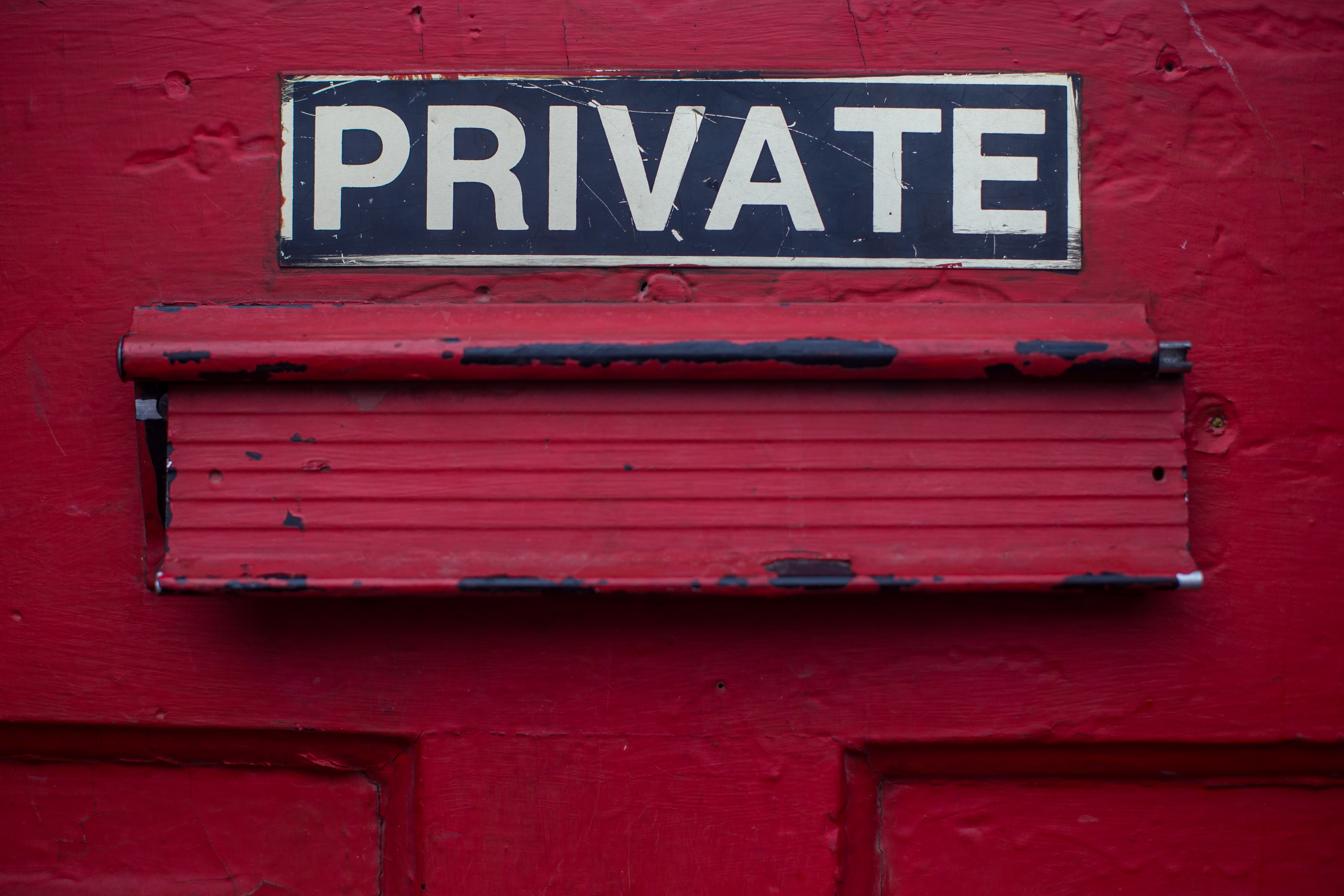 Image shows the word Private written above a letterbox of a red door