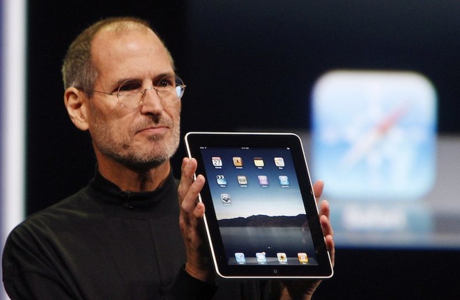 Steve Jobs holding up an iPad