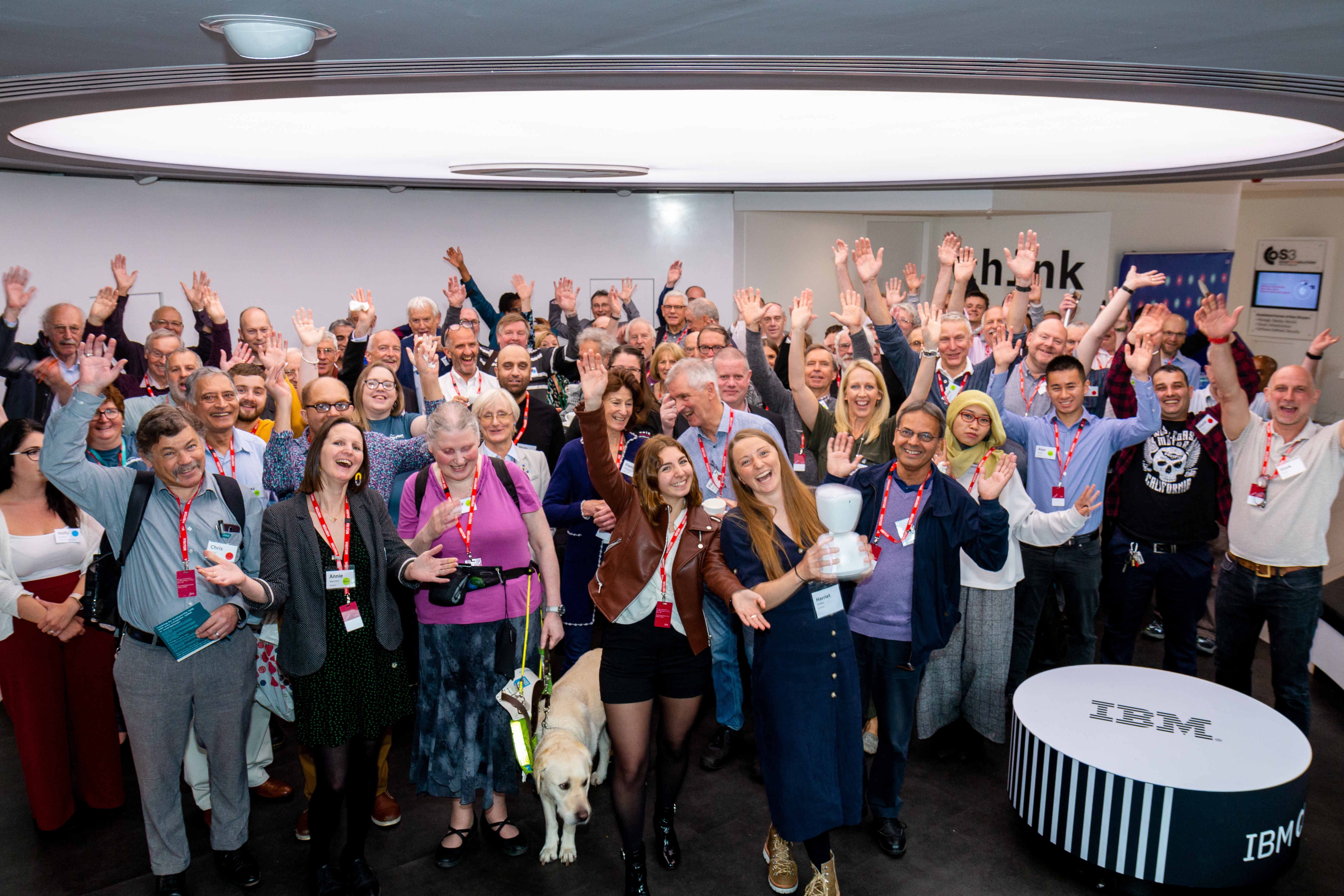 A picture of the 2019 volunteer events shows attendees together with arms in the air