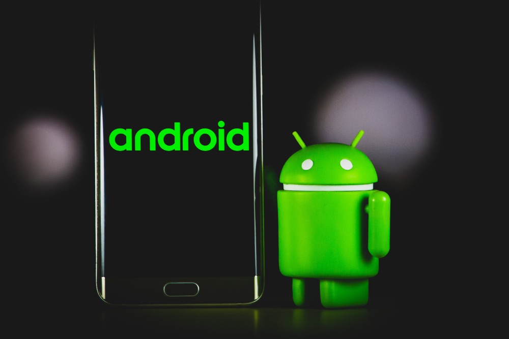 Android phone with 'Android' written on it, with green Android robot 'standing' next to it