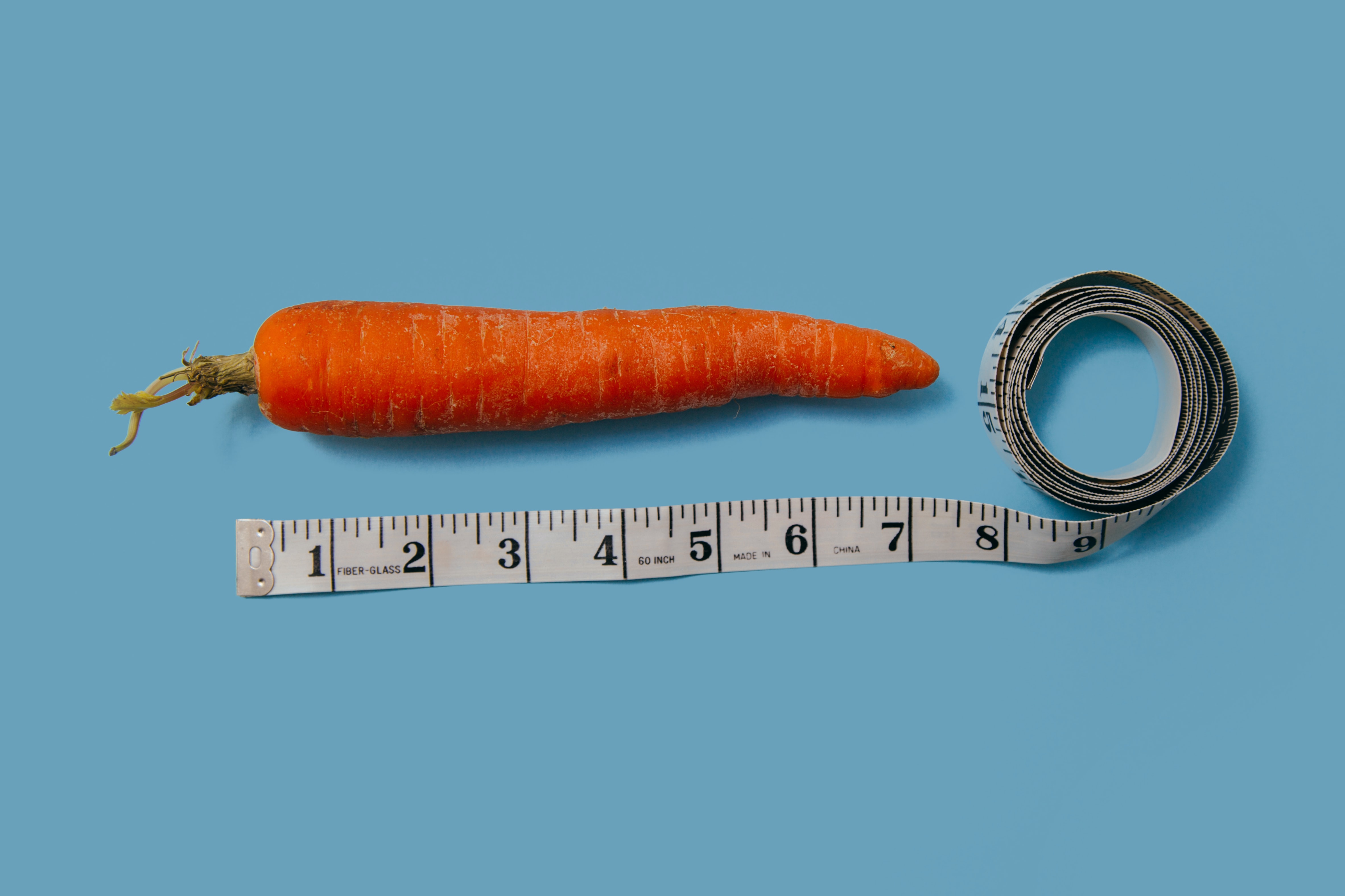 image shows a carrot with a tape measure alongside it