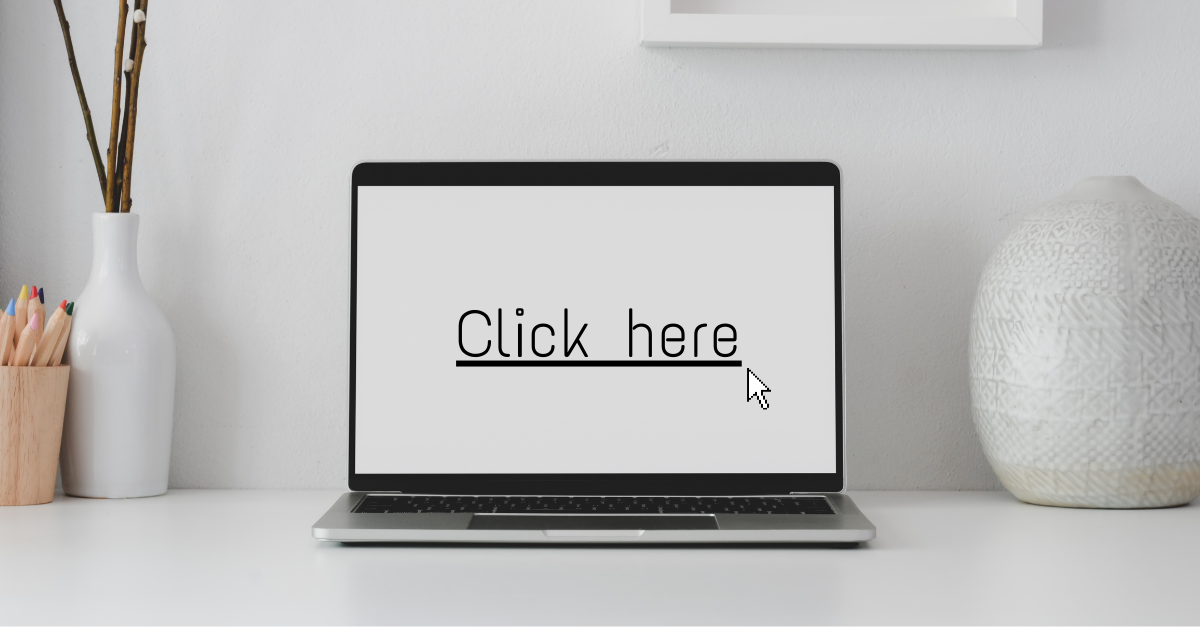 Open laptop with underlined text displaying "click here". 