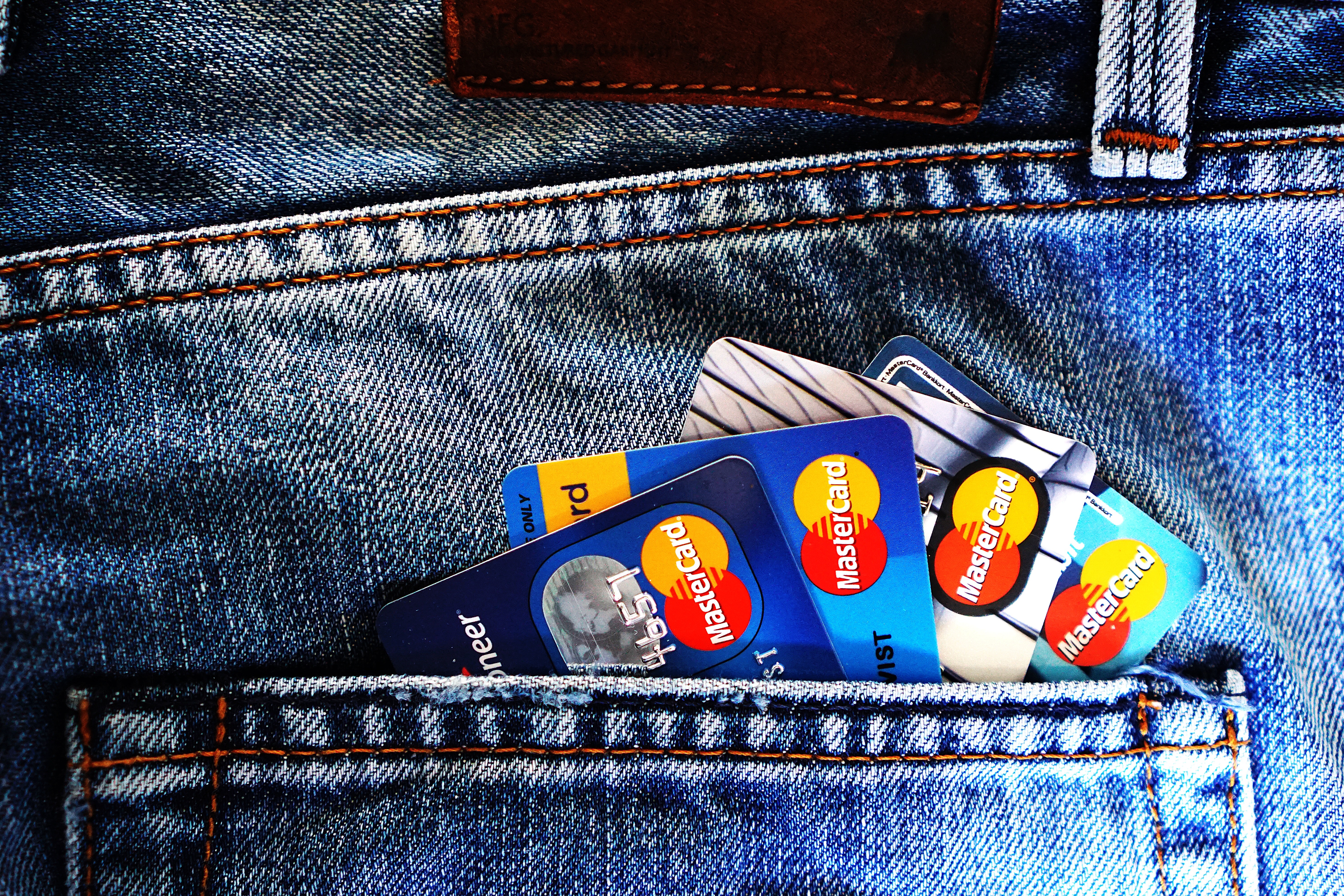Credit cards arranged in a fan design in a back pocket of some denim jeans