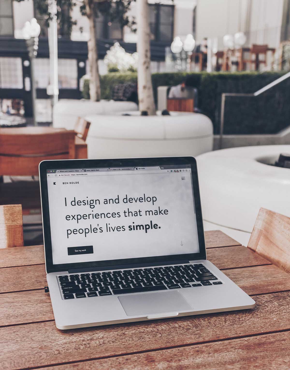  Laptop showing text reading the words "I design and develop experiences that make people's lives simple"