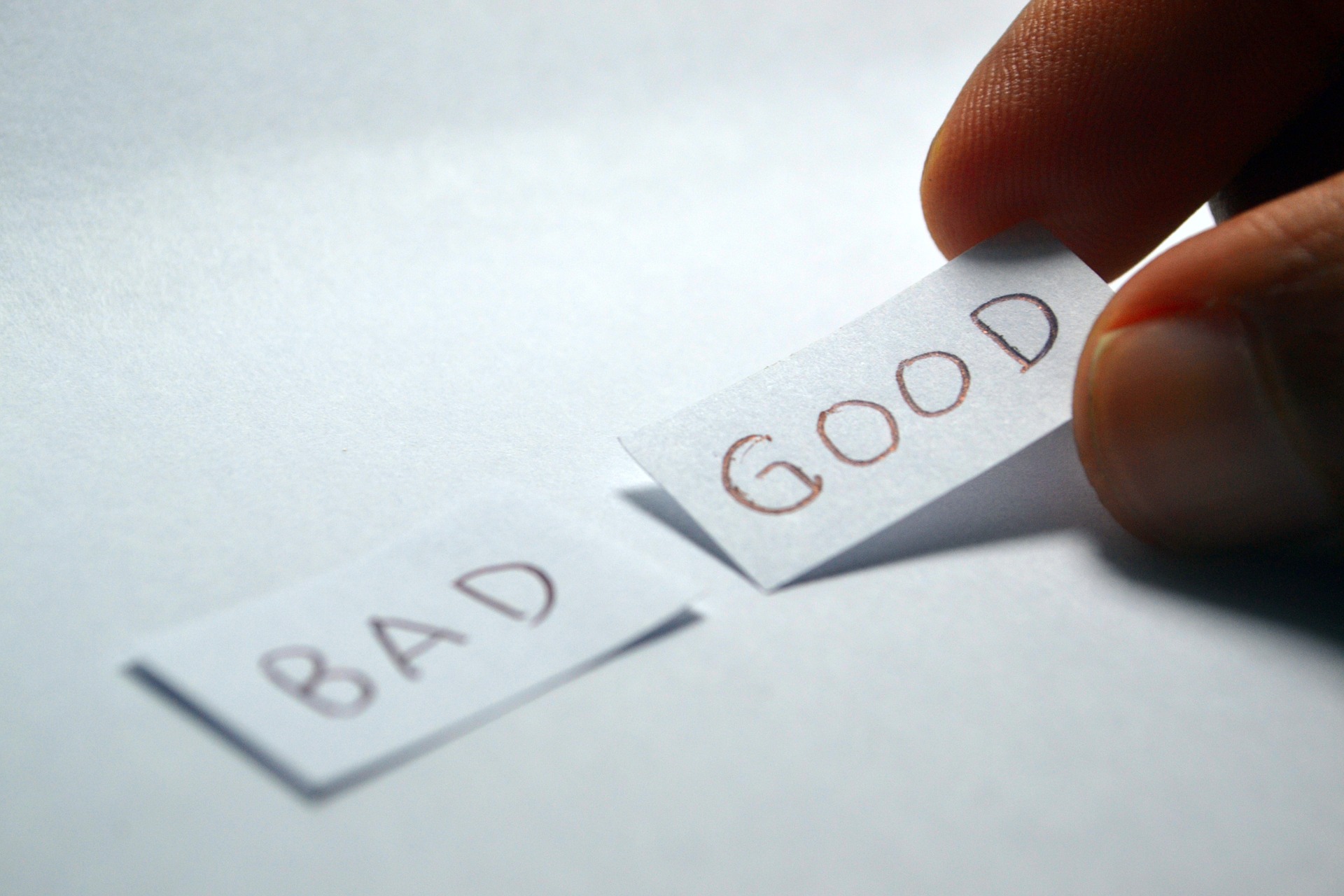 image: 2 pieces of paper saying bad and good. A hand is picking up the one that says good