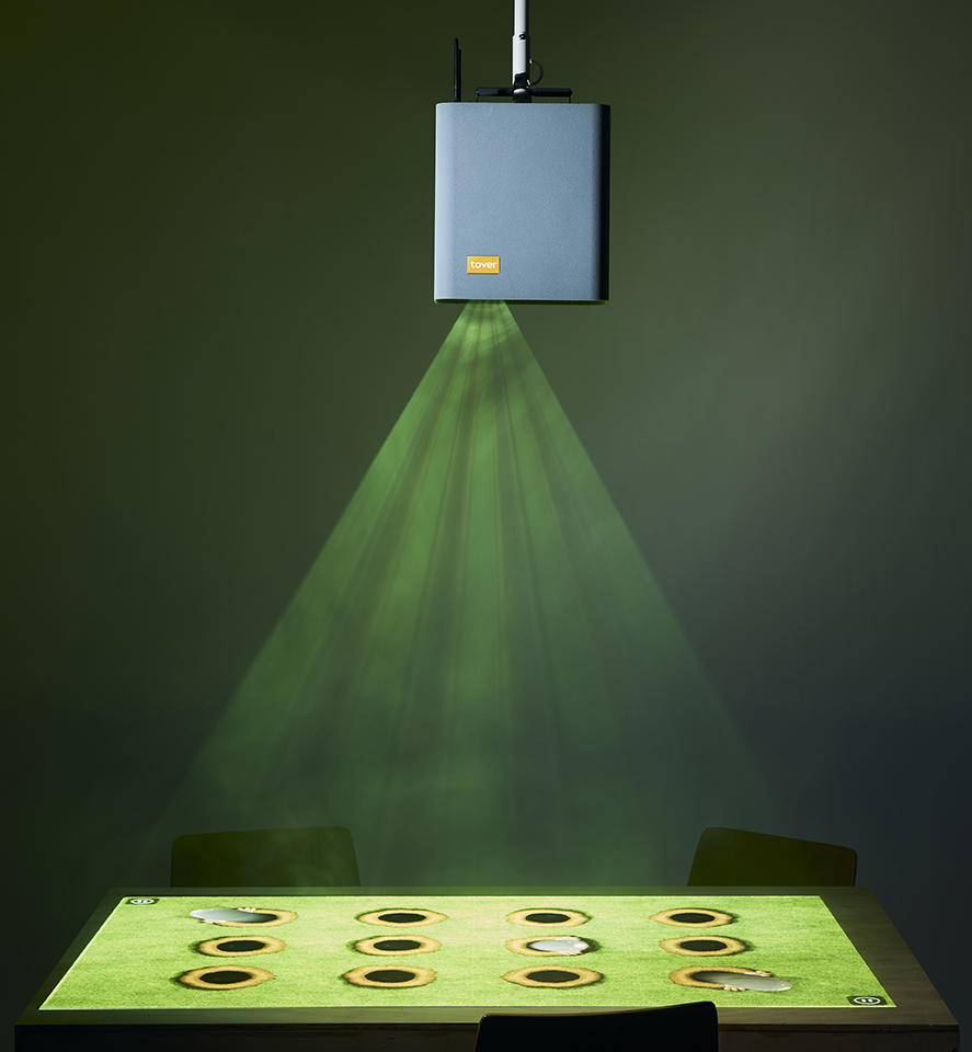 Image shows the projector above a table. There are images of sunflowers projected onto the table